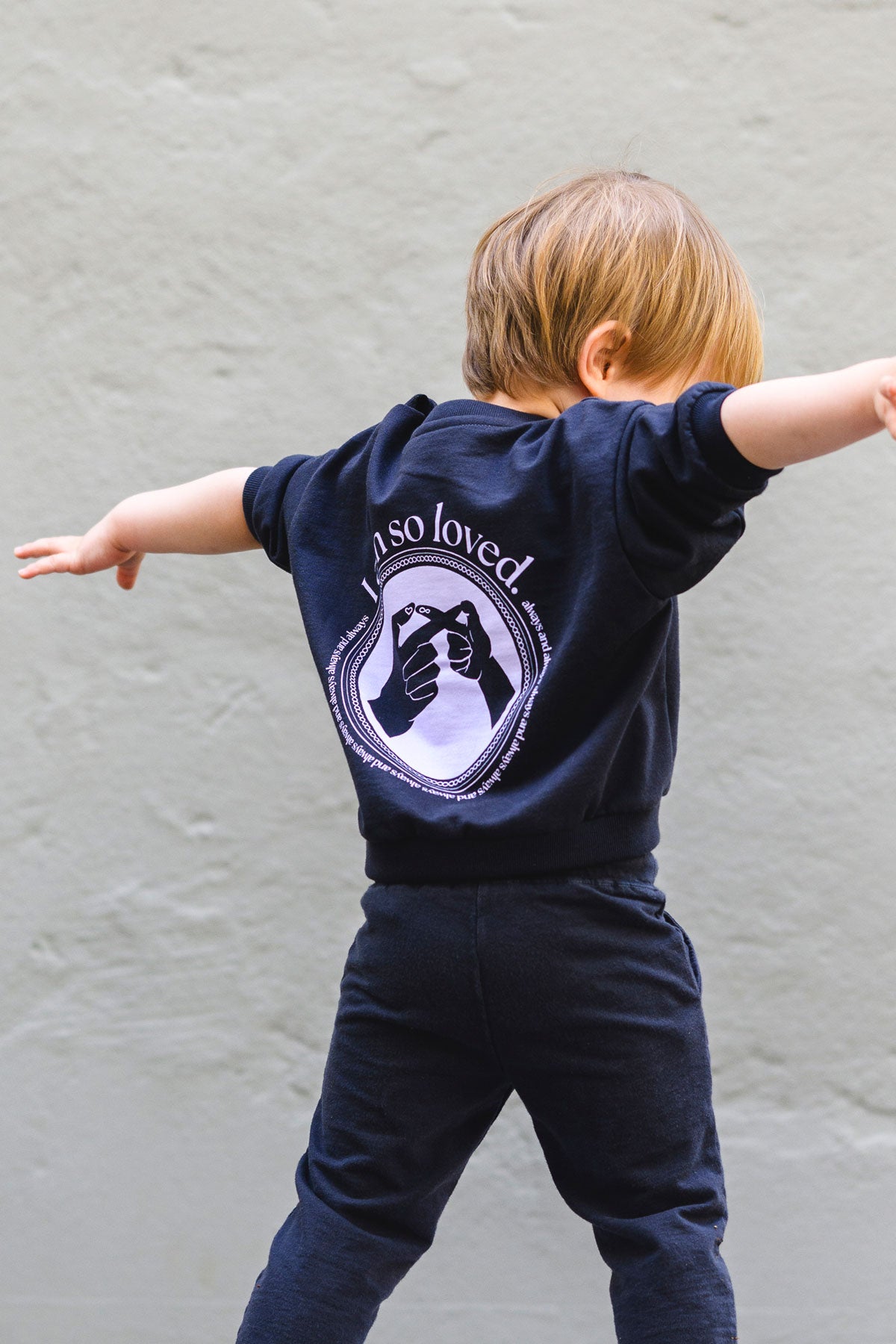 Kind trägt anthrazit farbenes Sweatshirt mit Lavendel Print