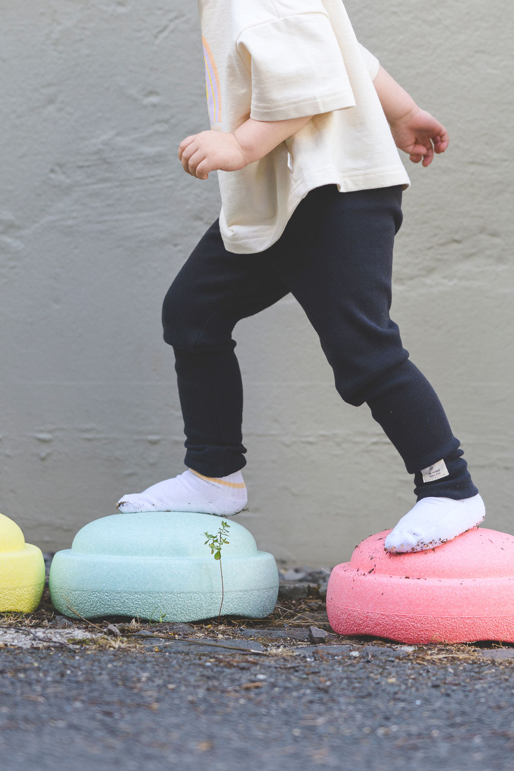 Kind trägt lockere Leggings in Anthrazit mit Aufschrift "so loved"