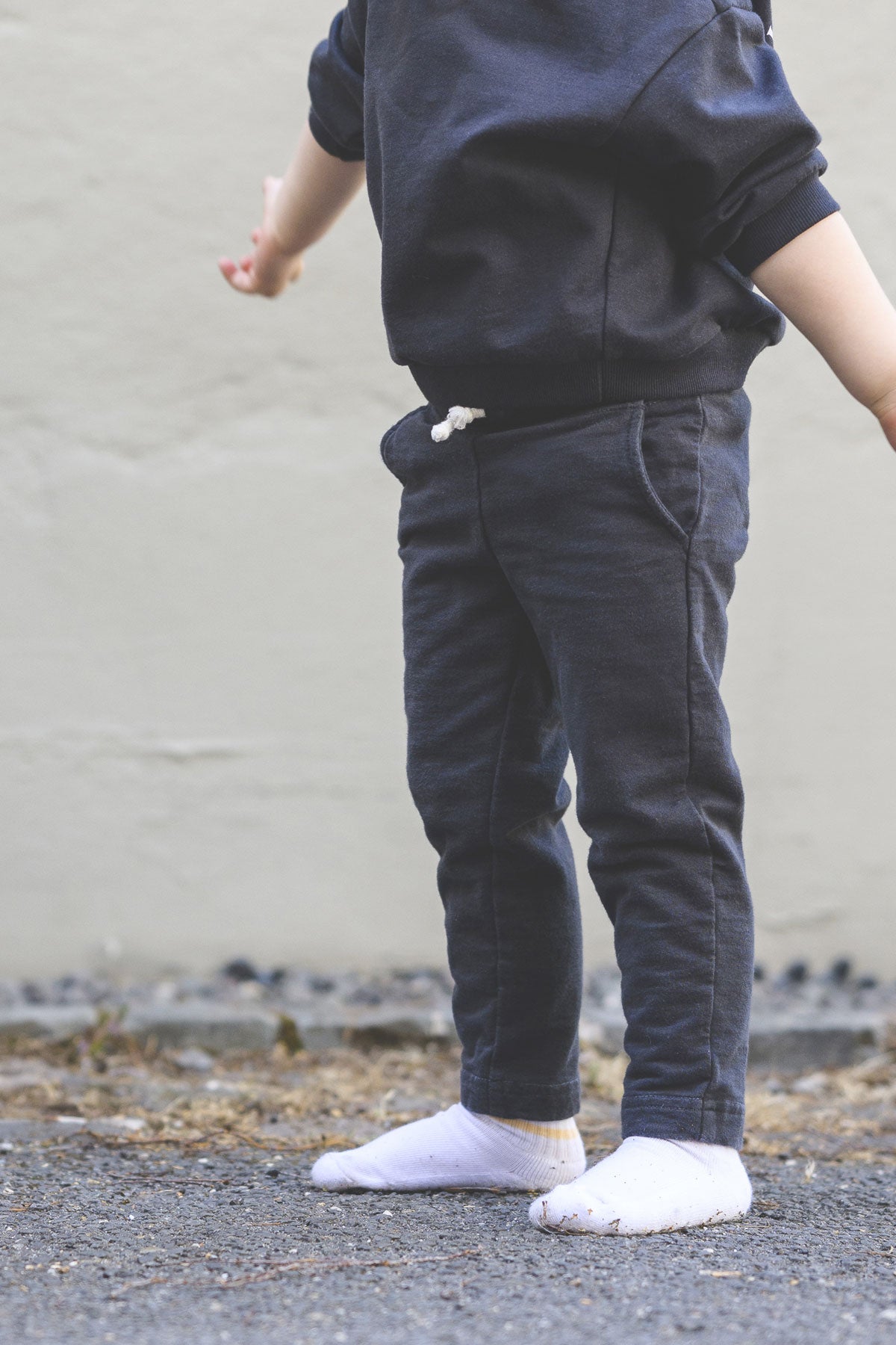 Kind trägt anthrazitfarbene gerade Hose