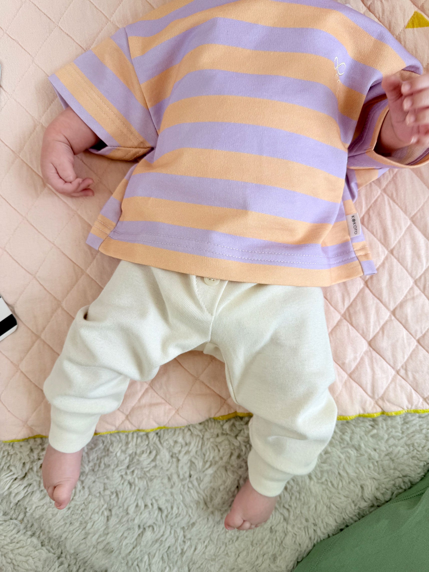Baby trägt boxy gestreiftes tshirt mit Herz Stickerei und Babyhose