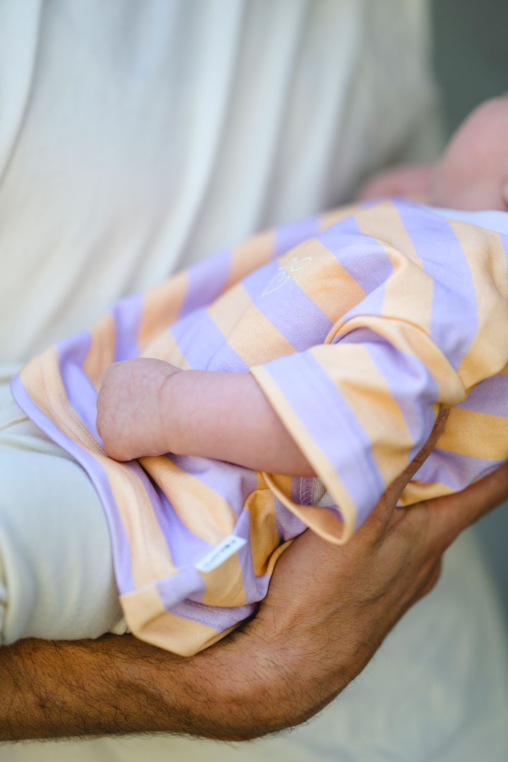 baby trägt ein weites gestreiftes t-shirt mit Stickerei