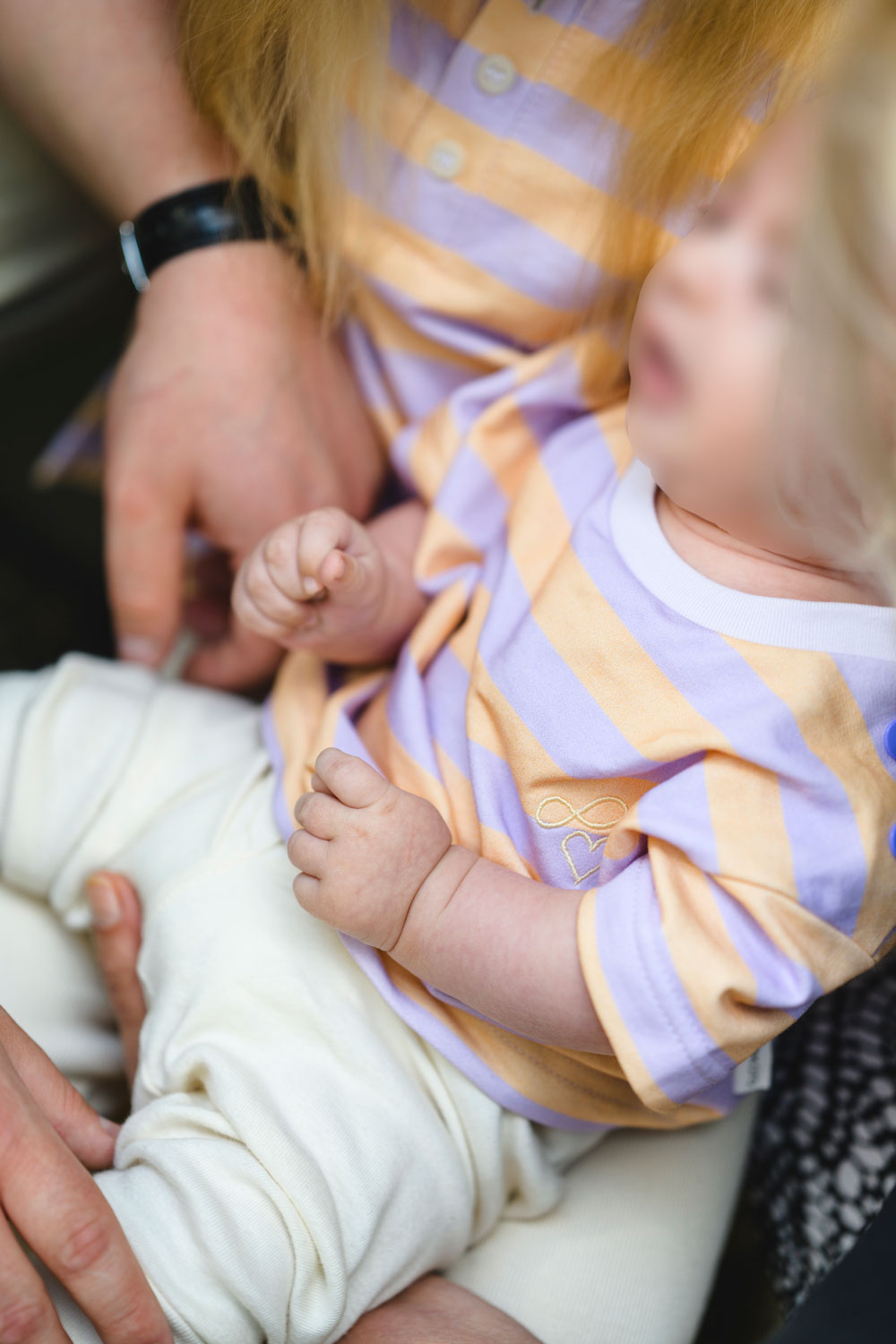 Baby trägt gestreiftes T-Shirt mit Stickerei in Lavendel und peach